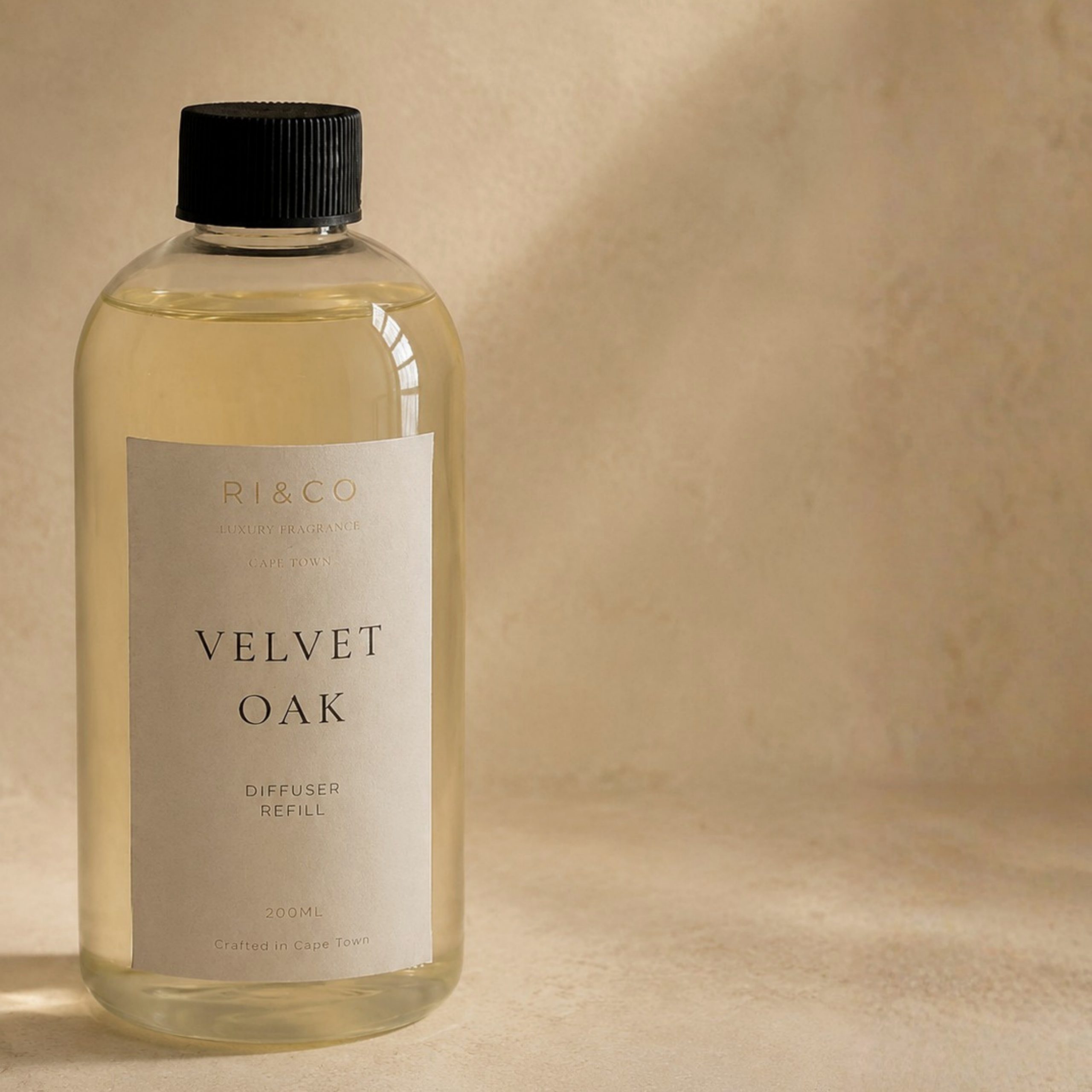 Luxury Velvet Oak reed diffuser refill by RI&CO in a minimalist transparent bottle with warm neutral luxury styling.
